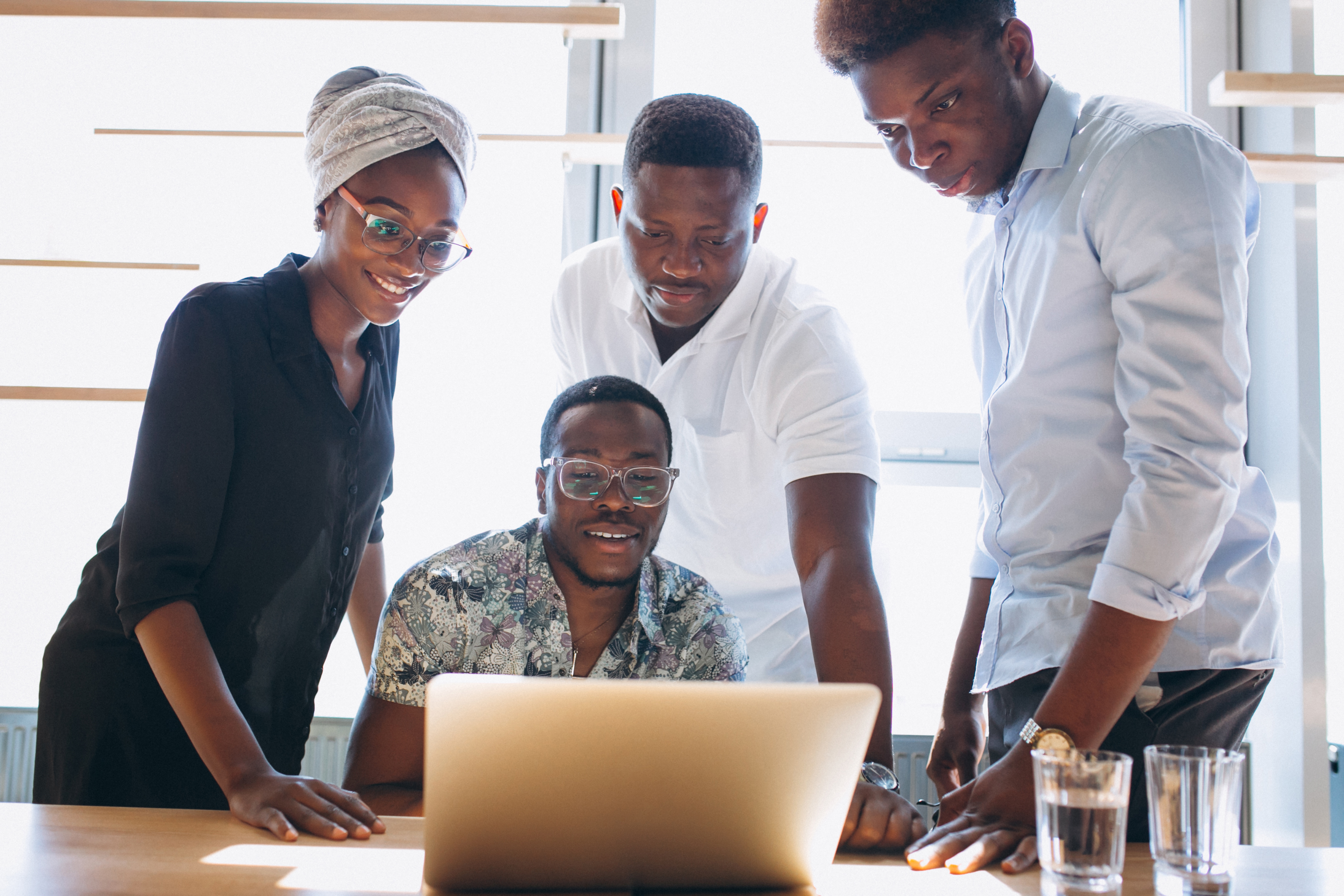 A group of people looking at a laptop